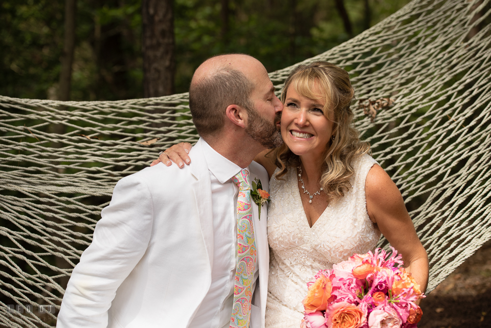 At home backyard wedding Groom kiss Bride on hammock laughing photo by Leo Dj Photography