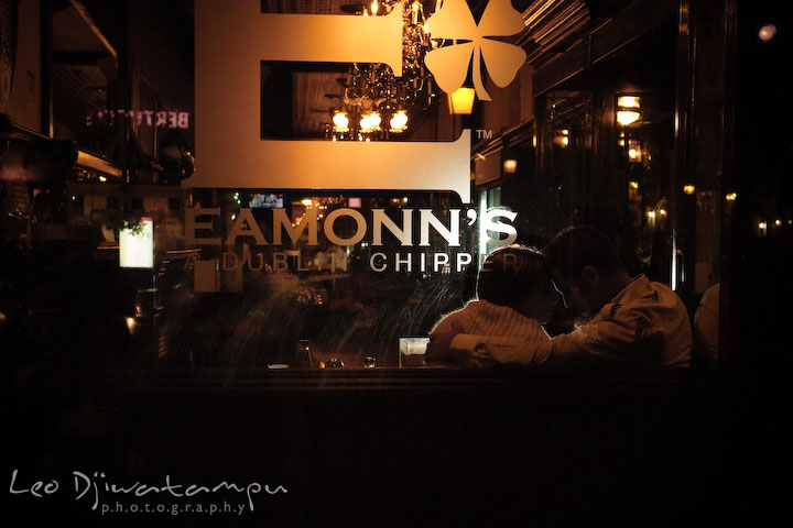 Engaged girl cuddles with her fiancee at Eamonn's restaurant. Candid Old Town Alexandria Virginia Engagement Photography Session by Wedding Photographer Leo Dj