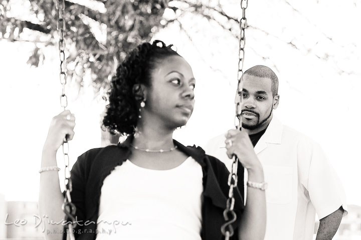 engaged couple playing swing. guy pushed girl. Federal Hill Park Baltimore pre-wedding engagement portrait