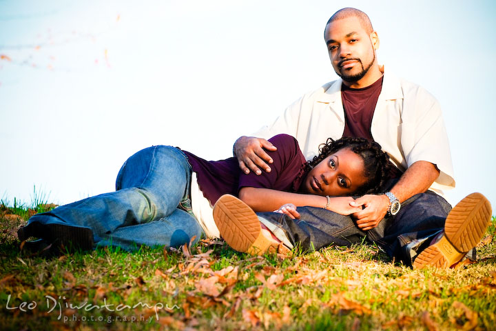 girl sitting laying on grass, leaning head on guy's lap. Federal Hill Park Baltimore pre-wedding engagement portrait