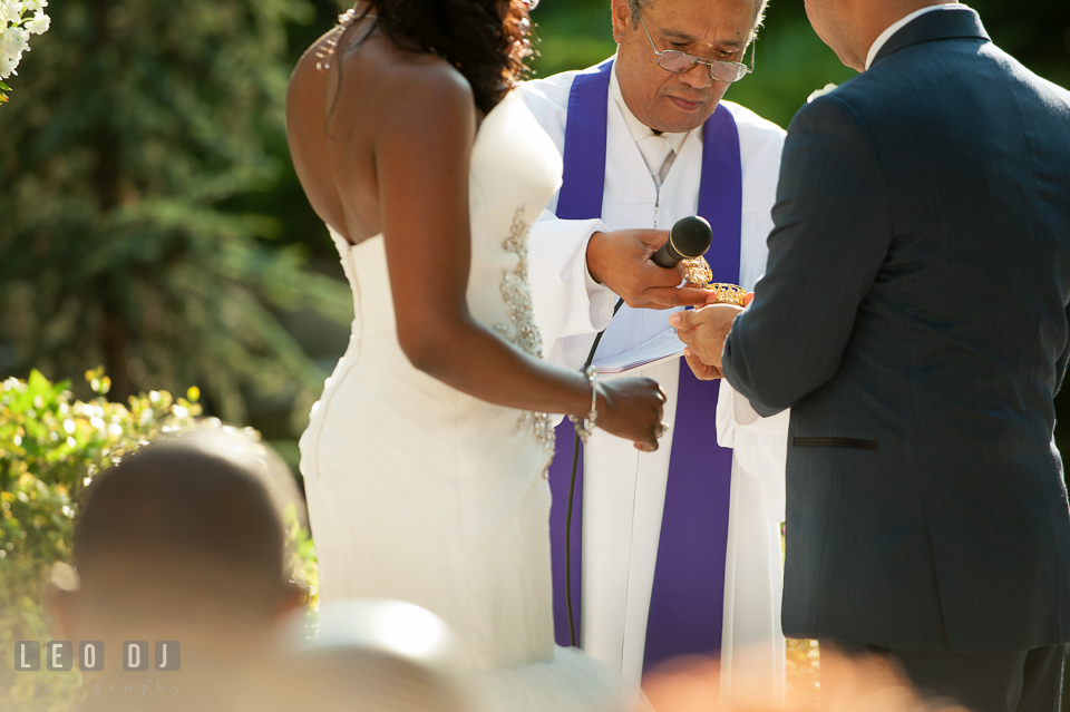 The wedding officiant, Reverend Julian Bermudez, opening the gold coin box. Falls Church Virginia 2941 Restaurant wedding ceremony and reception photo, by wedding photographers of Leo Dj Photography. http://leodjphoto.com