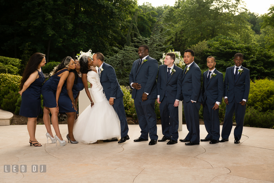 The Bride and Groom kissing and watched by the bridal party and groom's party. Falls Church Virginia 2941 Restaurant wedding ceremony and reception photo, by wedding photographers of Leo Dj Photography. http://leodjphoto.com