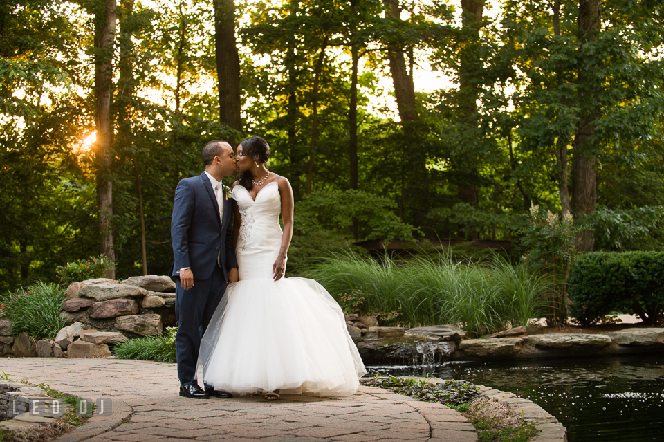 Bride and Groom kissing by the woods and pond during sunset. Falls Church Virginia 2941 Restaurant wedding ceremony and reception photo, by wedding photographers of Leo Dj Photography. http://leodjphoto.com