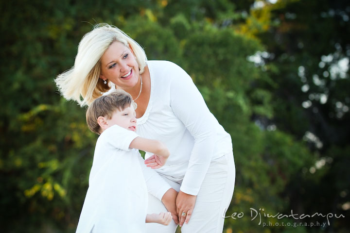 A boy throwing rock to the water, watched by mother. Kent Island, Annapolis, MD Fun Candid Family Lifestyle Photographer, Leo Dj Photography