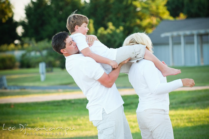 Dad helping son to get down from mom's shoulder. Kent Island, Annapolis, MD Fun Candid Family Lifestyle Photographer, Leo Dj Photography