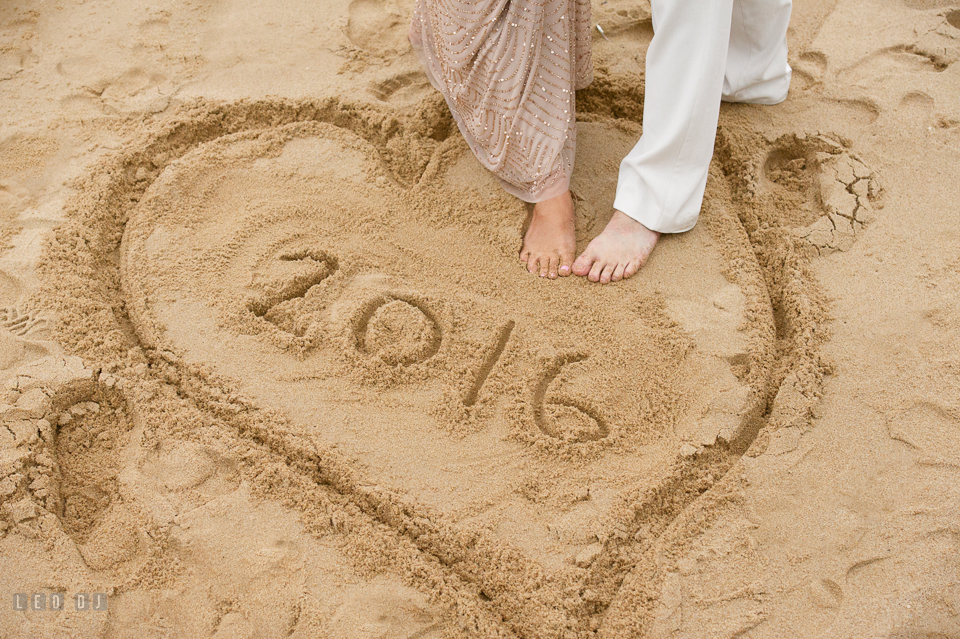 Silver Swan Bayside Groom and Bride's feet on a heart shaped sand drawing photo by Leo Dj Photography