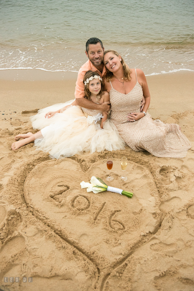 Silver Swan Bayside Groom, Bride, and daughter by heart shaped sand drawing photo by Leo Dj Photography