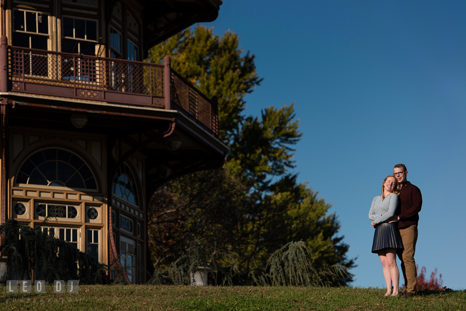 Patterson Park Baltimore Maryland engaged couple snuggling by the pagoda photo by Leo Dj Photography.