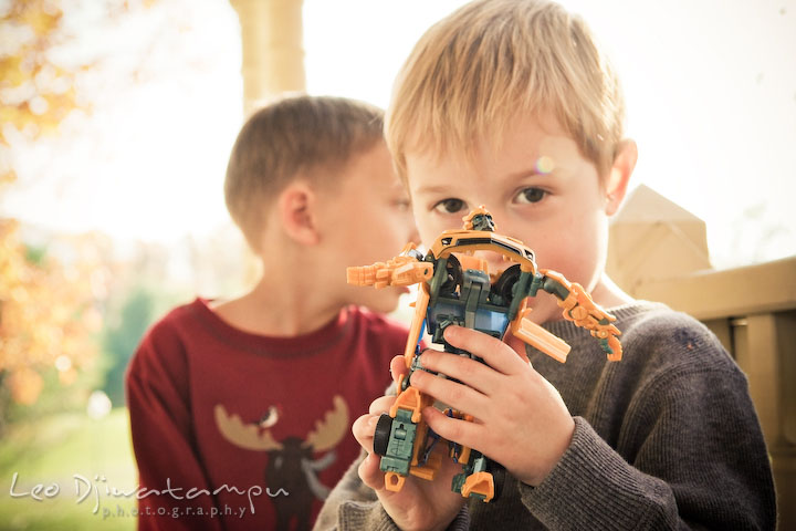 boy showing his transformers bumblebee robot car toy. Fun candid family children lifestyle photographer Annapolis Maryland