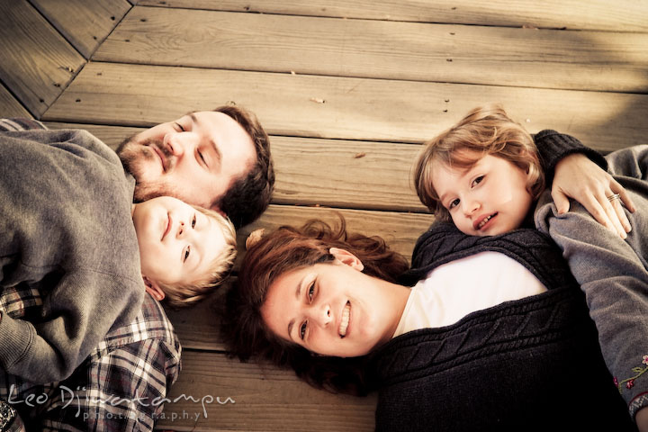 the whole family on the ground, smiling. Fun candid family children lifestyle photographer Annapolis Maryland