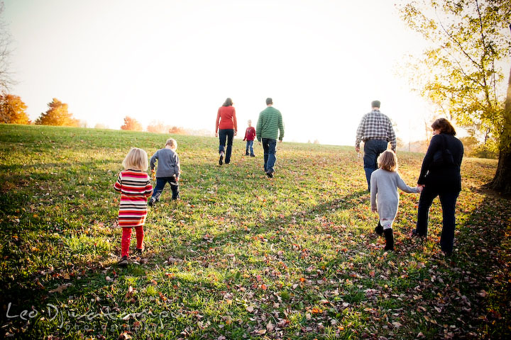 two families walking together toward the sunset on the horizon.