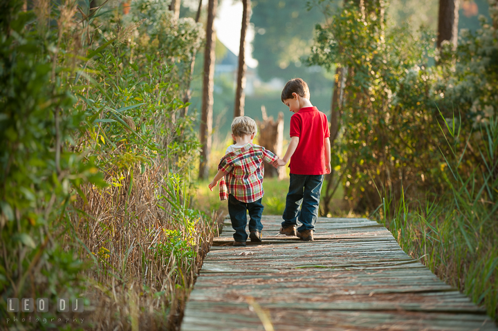 Two toddler boys walking together holding hands. Queenstown, Eastern Shore Maryland candid children and family lifestyle portrait photo session by photographers of Leo Dj Photography. http://leodjphoto.com