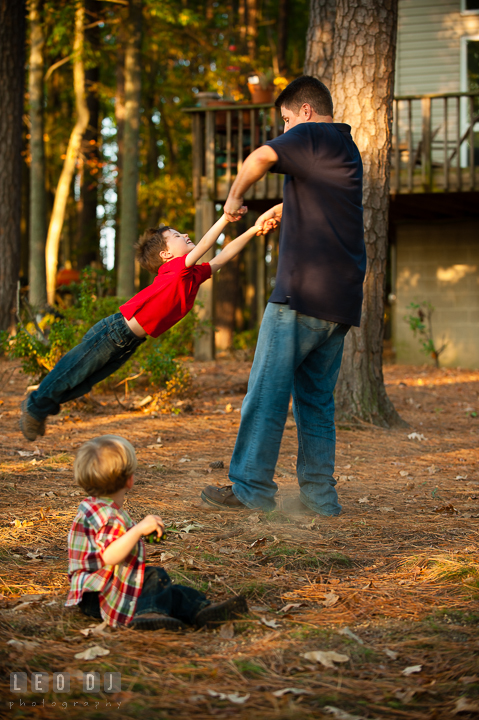 Dad swinging his son. Queenstown, Eastern Shore Maryland candid children and family lifestyle portrait photo session by photographers of Leo Dj Photography. http://leodjphoto.com