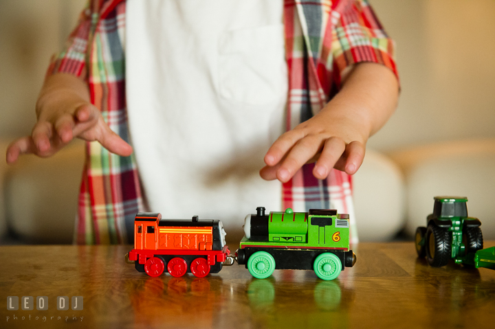 Little boy playing with trains and locomotive from Thomas. Queenstown, Eastern Shore Maryland candid children and family lifestyle portrait photo session by photographers of Leo Dj Photography. http://leodjphoto.com