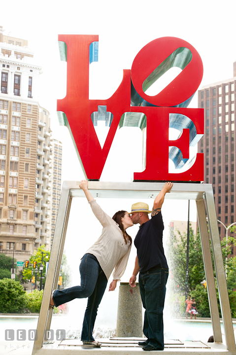 Engaged guy kissing his fiancée. Pre-wedding or engagement photo session at Phillies Ball Park, Love Park, Philadelphia, by wedding photographers of Leo Dj Photography.