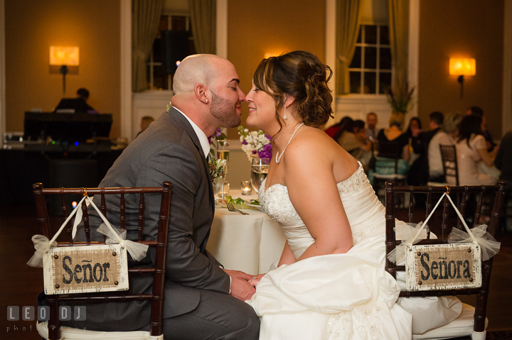 Bride and Groom at sweet heart table holding hands and almost kissed. The Tidewater Inn Wedding, Easton Maryland, reception photo coverage by wedding photographers of Leo Dj Photography. http://leodjphoto.com