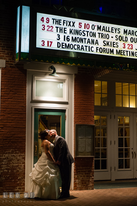 Groom kissing Bride outside in the city in front of a theater. The Tidewater Inn Wedding, Easton Maryland, reception photo coverage by wedding photographers of Leo Dj Photography. http://leodjphoto.com