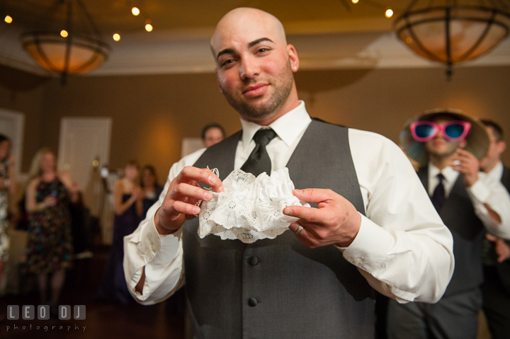 Groom holding the garter in his hands. The Tidewater Inn Wedding, Easton Maryland, reception photo coverage by wedding photographers of Leo Dj Photography. http://leodjphoto.com