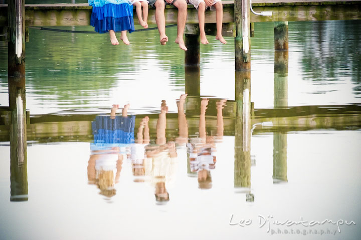 Feet and legs hanging from pier, with the family's shadow on the water. Kent Island and Annapolis, Eastern Shore, Maryland Candid Family Maternity Session Photographer