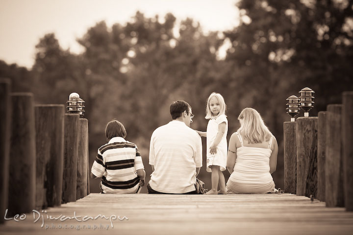 Family sitting on pier, little girl looking at camera. Kent Island and Annapolis, Eastern Shore, Maryland Candid Family Maternity Session Photographer