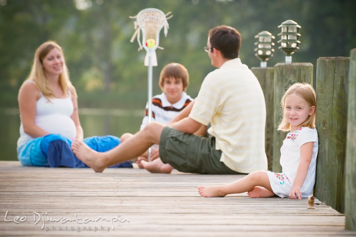 Little girl, daughter, posing on pier, family in the back. Kent Island and Annapolis, Eastern Shore, Maryland Candid Family Maternity Session Photographer