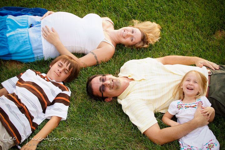 Family (father, mother, son and daughter) laying on the grass, laughing. Kent Island and Annapolis, Eastern Shore, Maryland Candid Family Maternity Session Photographer