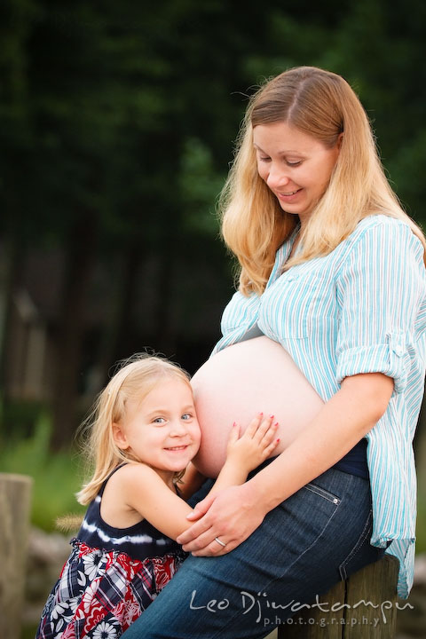 Daughter, little girl, hugging her pregnant mother's belly. Kent Island and Annapolis, Eastern Shore, Maryland Candid Family Maternity Session Photographer