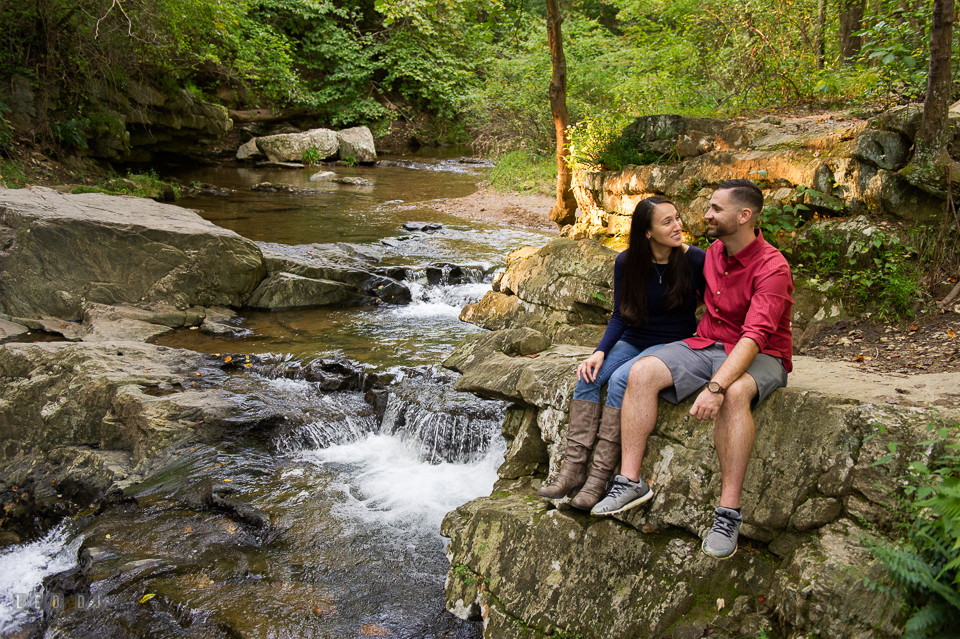 Rocks State Park Bel Air Maryland engaged couple sitting on rocks by a waterfall photo by Leo Dj Photography.