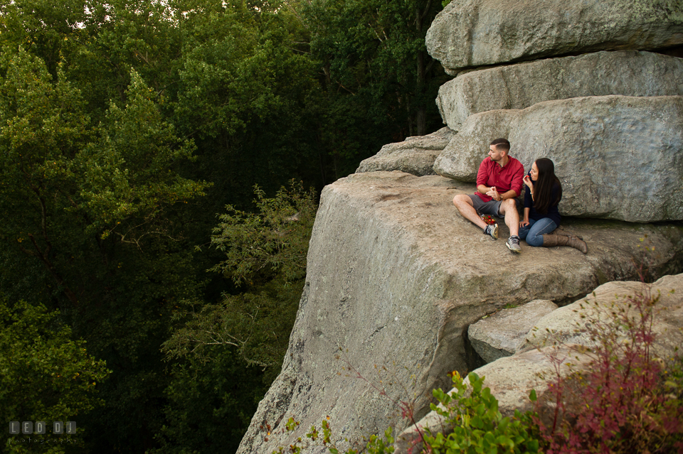 Rocks State Park Bel Air Maryland engaged couple eating stawberries on top of a cliff photo by Leo Dj Photography.