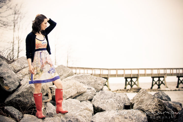 model girl brushing hair, standing on rocks by the beach. Engagement session model photography - Annapolis photographer
