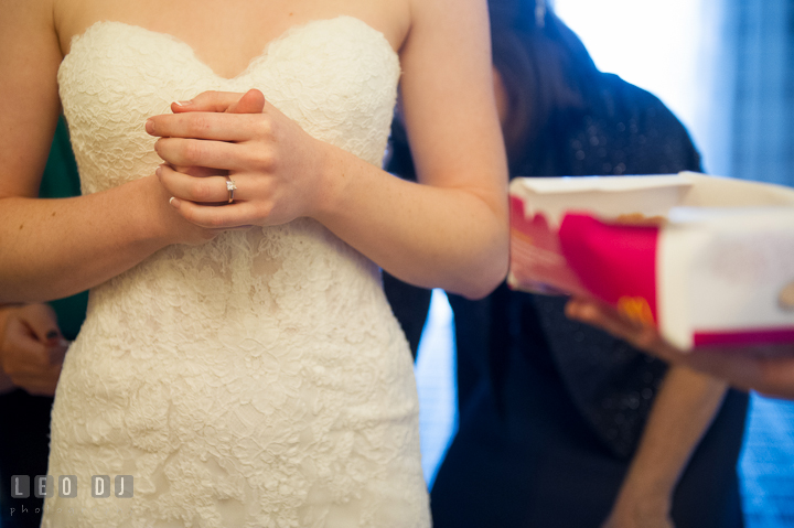 Bridesmaid offering some fries to Bride while Mother and Maid of Honor help lacing up wedding gown. Hyatt Regency Chesapeake Bay wedding at Cambridge Maryland, by wedding photographers of Leo Dj Photography. http://leodjphoto.com