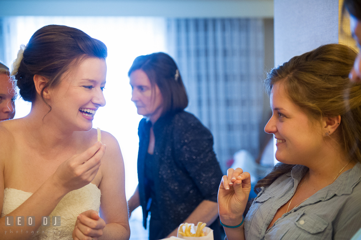 Bride and Bridesmaid laughing while eating fries while getting ready. Hyatt Regency Chesapeake Bay wedding at Cambridge Maryland, by wedding photographers of Leo Dj Photography. http://leodjphoto.com