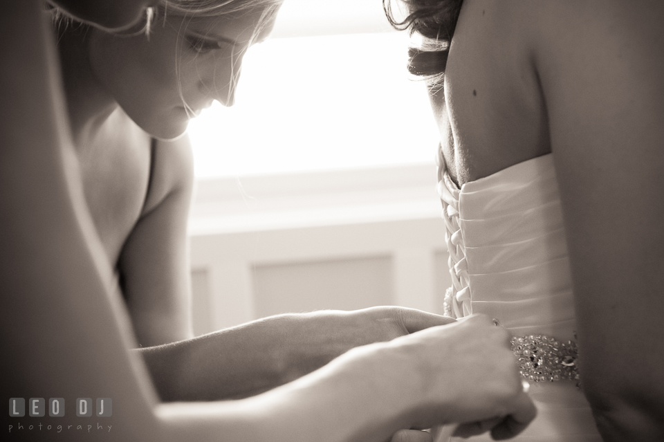 Bridesmaid and Matron of honor helping bride lace up her dress. Kent Island Maryland Chesapeake Bay Beach Club wedding photo, by wedding photographers of Leo Dj Photography. http://leodjphoto.com