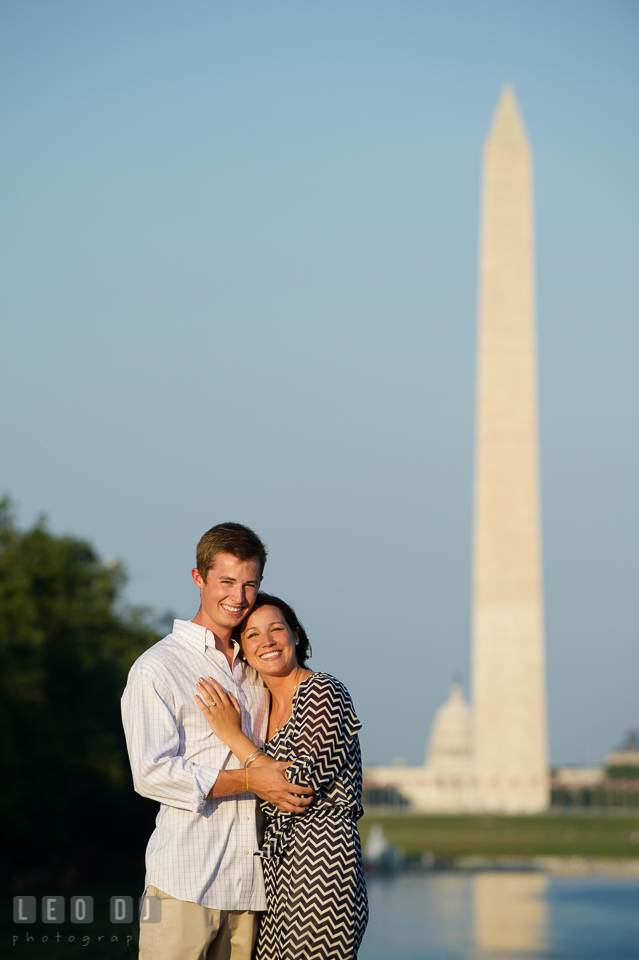 Engaged couple hugging and posing in front of the Monument and the Capitol Building. Washington DC pre-wedding engagement photo session at Lincoln Memorial, by wedding photographers of Leo Dj Photography. http://leodjphoto.com