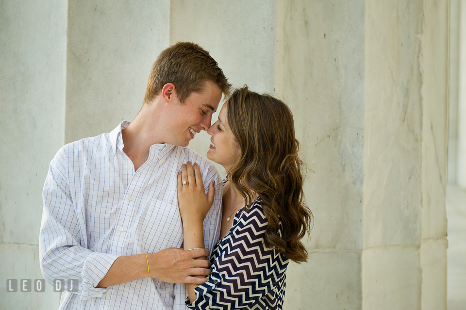 Engaged girl smiling with her fiancé by a large marble column. Washington DC pre-wedding engagement photo session at Lincoln Memorial, by wedding photographers of Leo Dj Photography. http://leodjphoto.com
