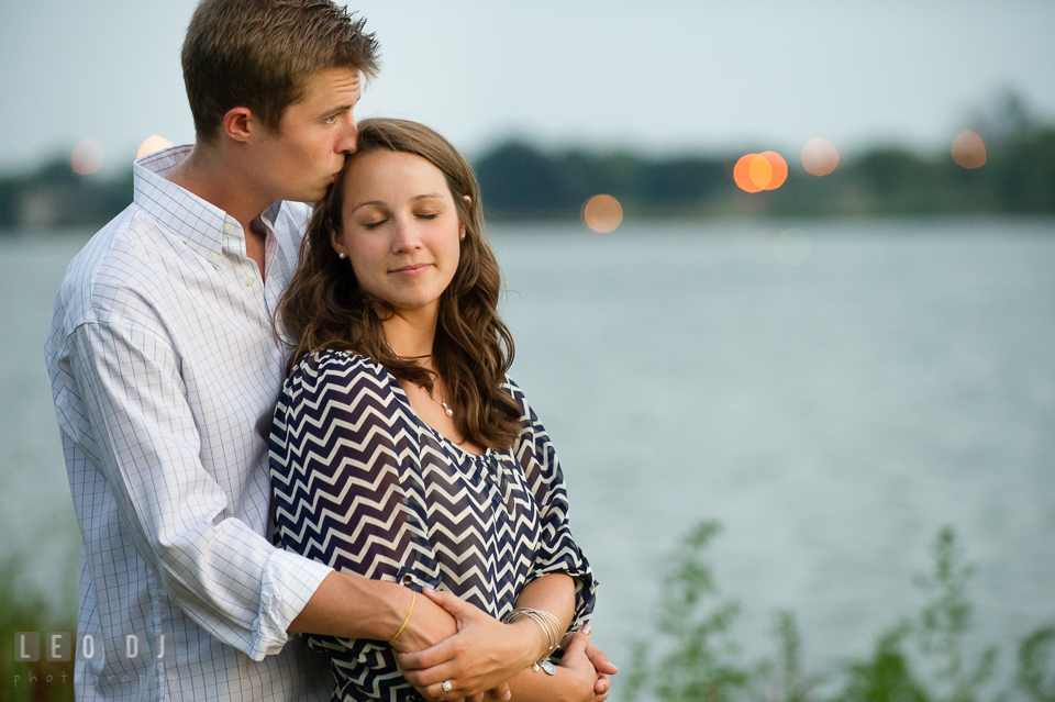 Engaged girl hugged and kissed by her fiance by the Tidal Basin. Washington DC pre-wedding engagement photo session at Lincoln Memorial, by wedding photographers of Leo Dj Photography. http://leodjphoto.com