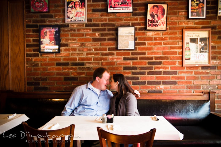 Engaged guy cuddling with his fiancée in a restaurant. Pre-wedding Engagement Photo Session Federal Hill Baltimore and Mother's Grille restaurant bar by wedding photographer Leo Dj Photography