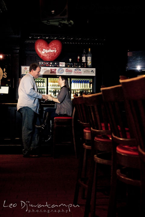 Engaged girl talking to her fiancé in a bar. Pre-wedding Engagement Photo Session Federal Hill Baltimore and Mother's Grille restaurant bar by wedding photographer Leo Dj Photography