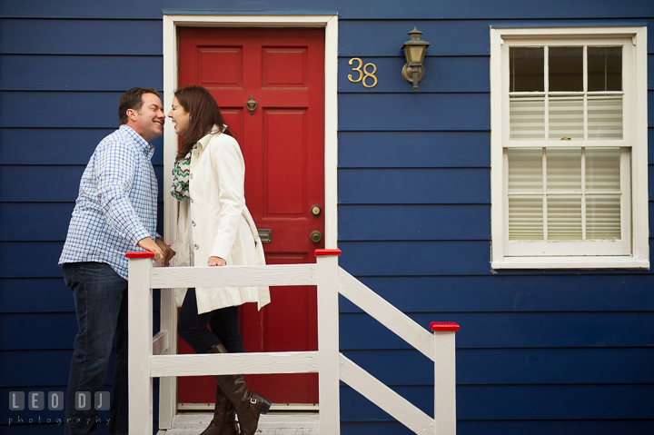 Engaged couple almost kissed in front of a rustic blue house with red door. Annapolis Eastern Shore Maryland pre-wedding engagement photo session at downtown, by wedding photographers of Leo Dj Photography. http://leodjphoto.com