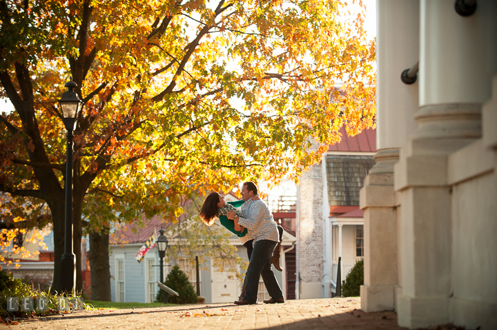 Engaged couple dancing and doing the dip under a yellow foliage tree in autumn. Annapolis Eastern Shore Maryland pre-wedding engagement photo session at downtown, by wedding photographers of Leo Dj Photography. http://leodjphoto.com