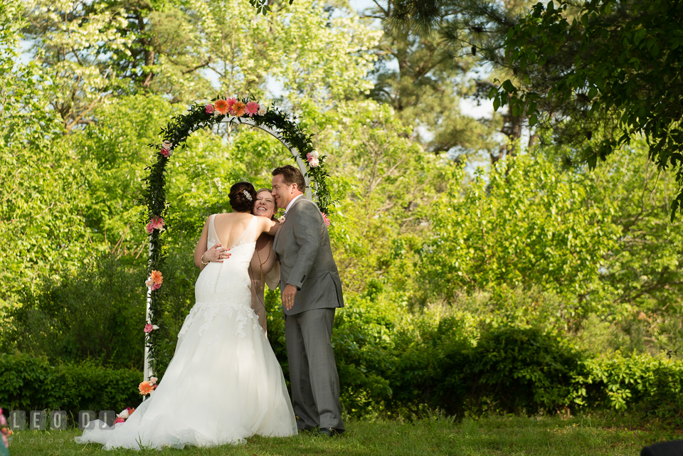 The officiant hugging the Bride and Groom after the wedding ceremony. Chesapeake Bay Environmental Center, Eastern Shore Maryland, wedding reception and ceremony photo, by wedding photographers of Leo Dj Photography. http://leodjphoto.com