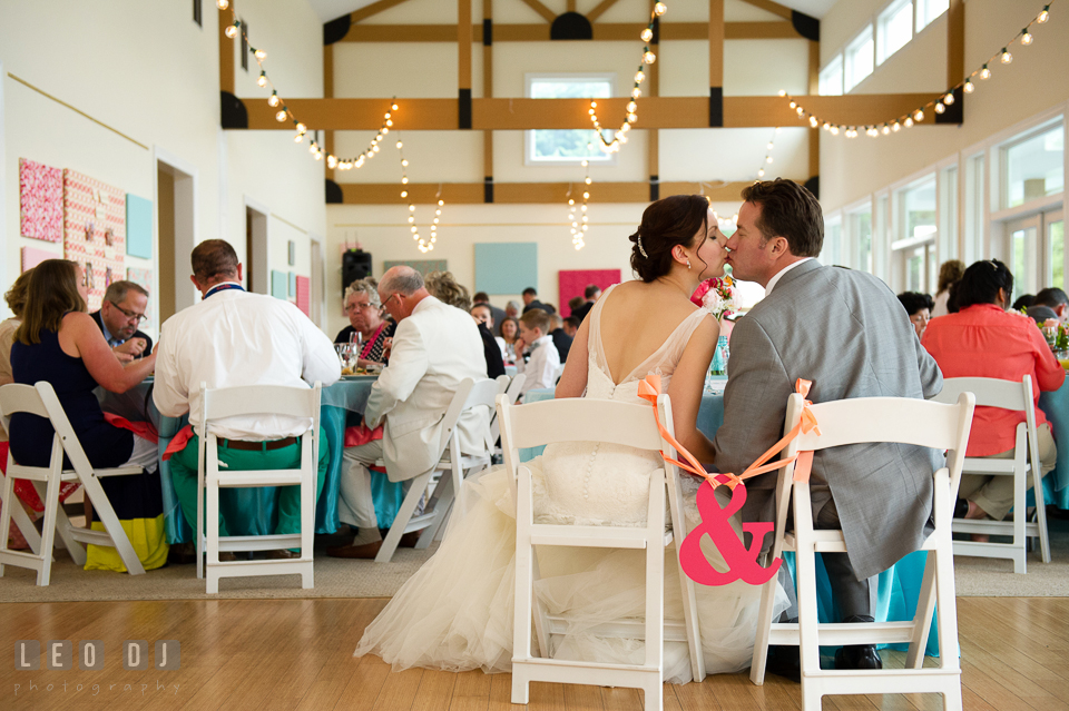 Bride and Groom kissing at the sweetheart table during the reception dinner. Chesapeake Bay Environmental Center, Eastern Shore Maryland, wedding reception and ceremony photo, by wedding photographers of Leo Dj Photography. http://leodjphoto.com