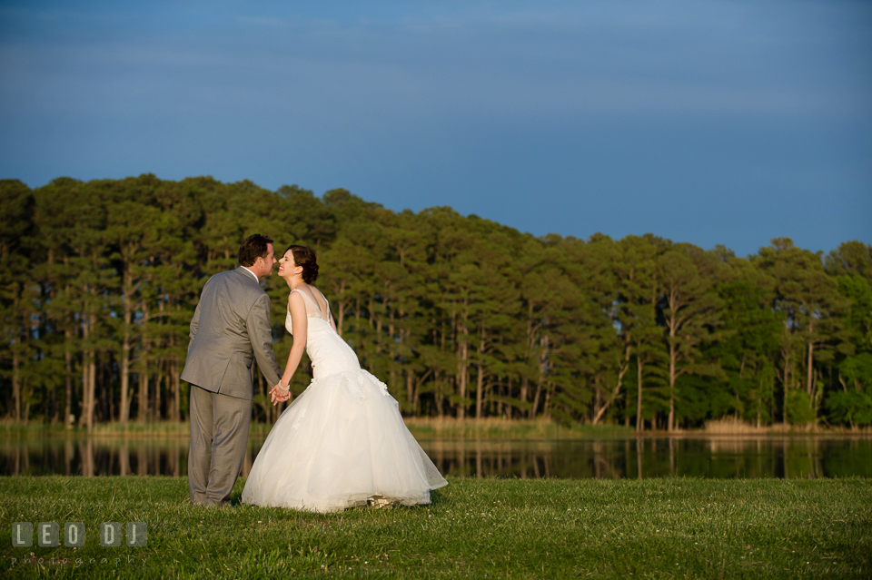 Bride and Groom standing and holding hands beside the beautiful lake. Chesapeake Bay Environmental Center, Eastern Shore Maryland, wedding reception and ceremony photo, by wedding photographers of Leo Dj Photography. http://leodjphoto.com