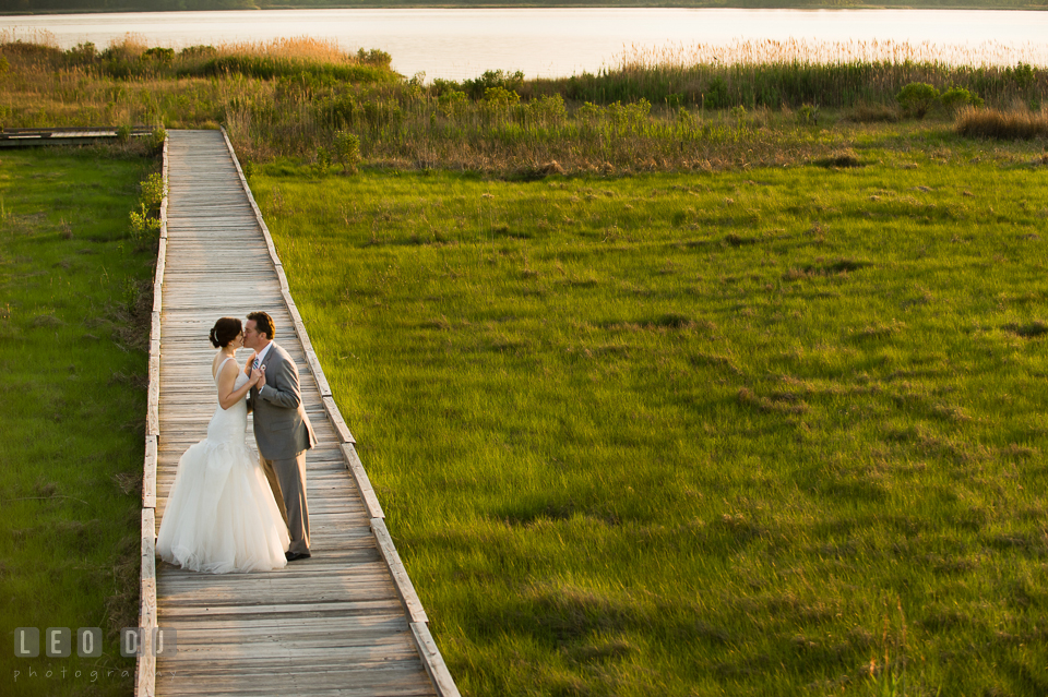 Bride and Groom kissing on the boardwalk by the beach. Chesapeake Bay Environmental Center, Eastern Shore Maryland, wedding reception and ceremony photo, by wedding photographers of Leo Dj Photography. http://leodjphoto.com