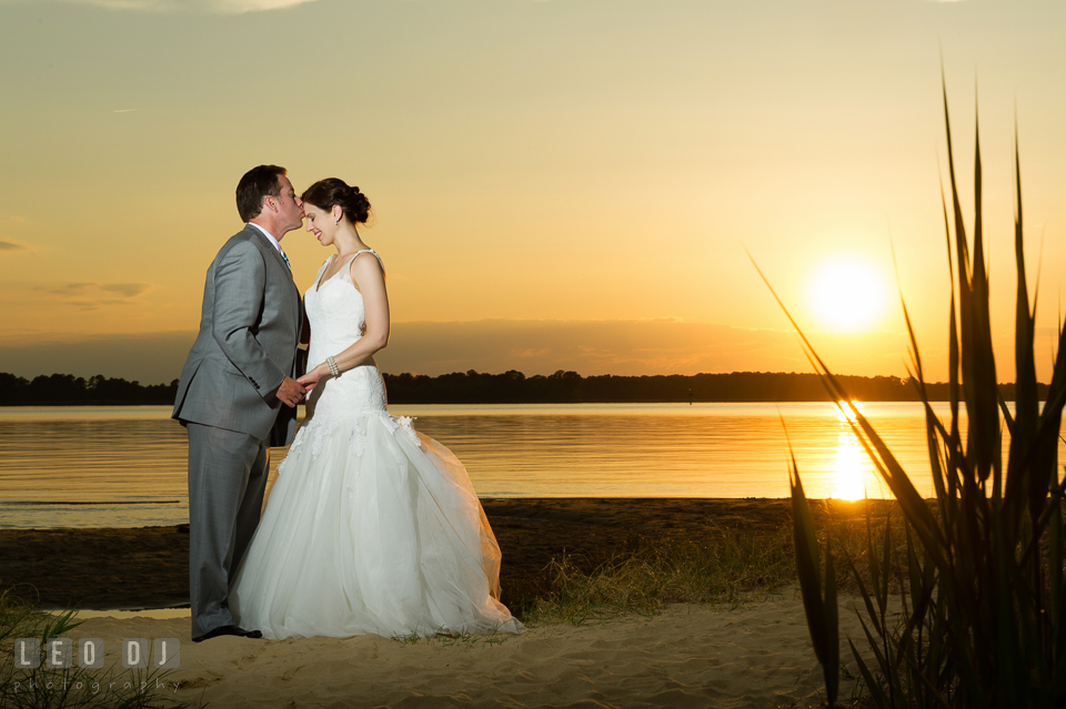 Groom kissing Bride during sunset on the beach. Chesapeake Bay Environmental Center, Eastern Shore Maryland, wedding reception and ceremony photo, by wedding photographers of Leo Dj Photography. http://leodjphoto.com