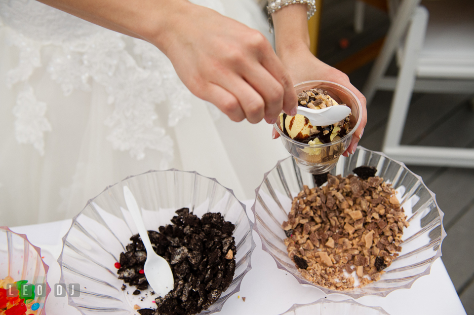 Bride sprinkles topping on delicious ice cream from Scottish Highland Creamery Sundae Bar. Chesapeake Bay Environmental Center, Eastern Shore Maryland, wedding reception and ceremony photo, by wedding photographers of Leo Dj Photography. http://leodjphoto.com