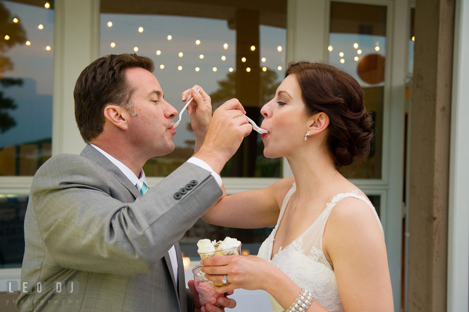 The Bride and Groom sharing scoops of ice cream from Scottish Highland Creamery Sundae Bar. Chesapeake Bay Environmental Center, Eastern Shore Maryland, wedding reception and ceremony photo, by wedding photographers of Leo Dj Photography. http://leodjphoto.com