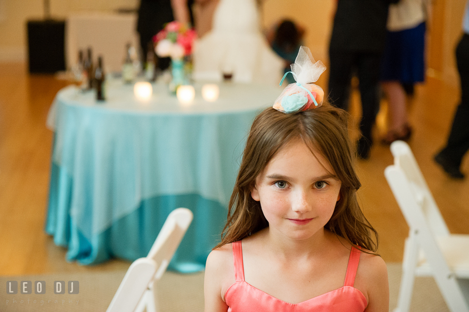 Flower girl balancing wedding favor on her head. Chesapeake Bay Environmental Center, Eastern Shore Maryland, wedding reception and ceremony photo, by wedding photographers of Leo Dj Photography. http://leodjphoto.com