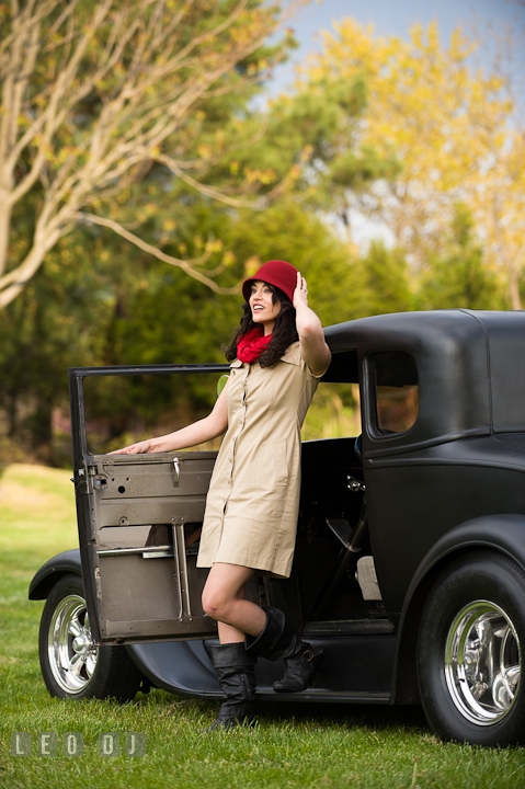 Girl stepping out of a vintage Ford model car, holding her red hat. Model portrait session with Brittany from Beyond the Veil music Band and her Siberian Husky pet dog at Kent Island, Maryland Eastern Shore by photographer Leo Dj Photography.