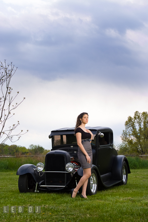 Girl posing by an antique Ford car. Dark clouds behind them. Eastern Shore, Maryland, Kent Island High School senior portrait session by photographer Leo Dj Photography. http://leodjphoto.com